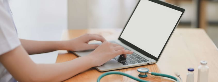 Doctor sitting at a desk on telehealth call with stethoscope nearby