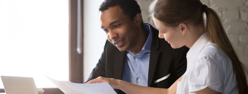 Female financial advisor insurer banker consulting male african american client about contract, caucasian mentor hr and black intern new employee discussing documents at meeting advice